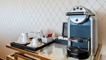 A Nespresso coffee machine on a tray with cups and a sugar bowl, set against a tiled wall.