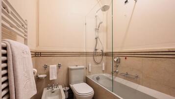 Une salle de bain dotée d’une douche à parois de verre, d’un bidet, de toilettes et d’une baignoire.