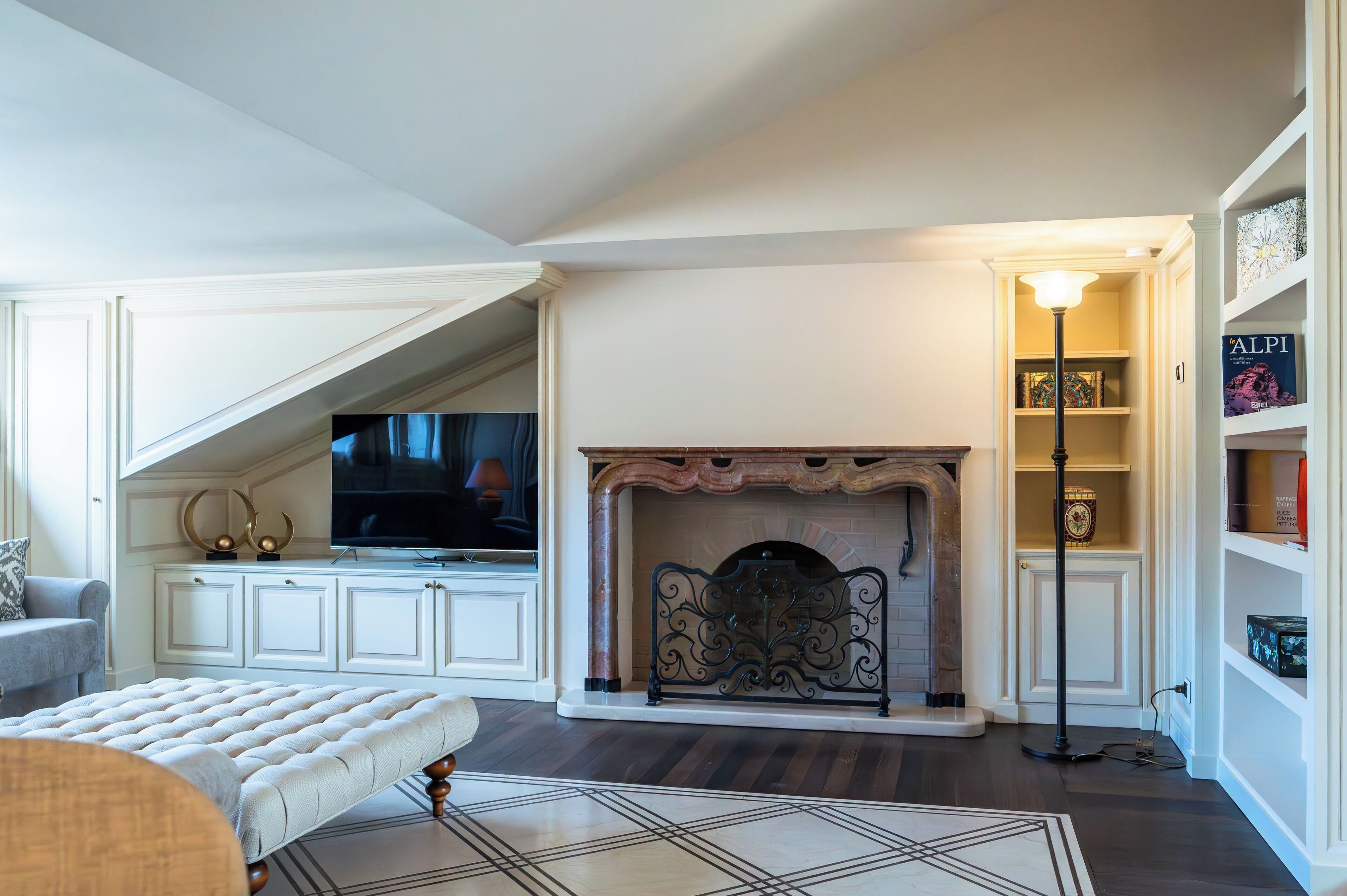 A living room with a fireplace, a television, and a bookshelf.