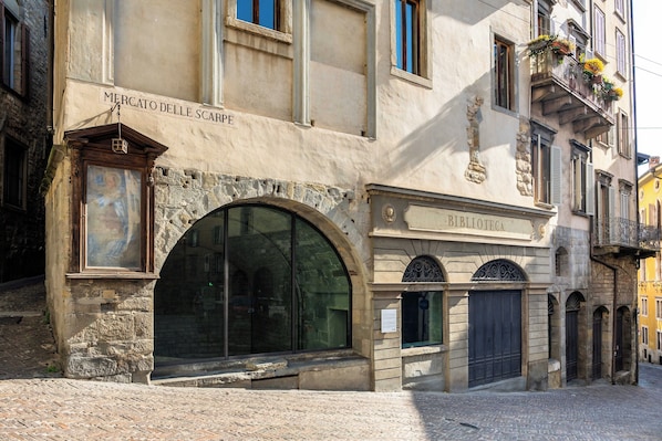 A building with a sign reading "Mercato delle Scarpette" and "Biblioteca" indicating a market and library. - Palazzo Porta Picta (Bergamo)