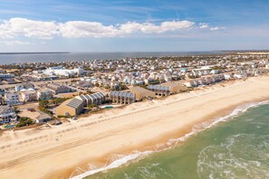 An aerial view of a coastal town with beachfront properties, including houses and a hotel with a beach view. - Newly updated oceanfront condo in Nags Head! (Nags Head)