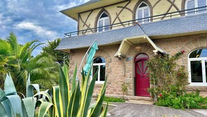 A stone house with a red door, a balcony, and a sign reading "La Parade." - "La Pagode"close to beache (Trégastel)