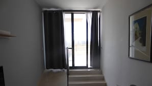A hallway leading to a staircase with a view of a building outside. - Seaview Ground Floor Flat Wheelchair Friendly (Zebbug)