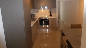 A compact kitchen with a stove, oven, and countertop. - Seaview Ground Floor Flat Wheelchair Friendly (Zebbug)
