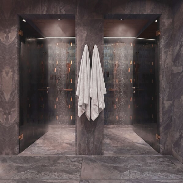 A modern bathroom with a marble floor, a central column with towels, and a shower with a glass enclosure. - SkyView Igloo Resort & Spa (Rovaniemi)