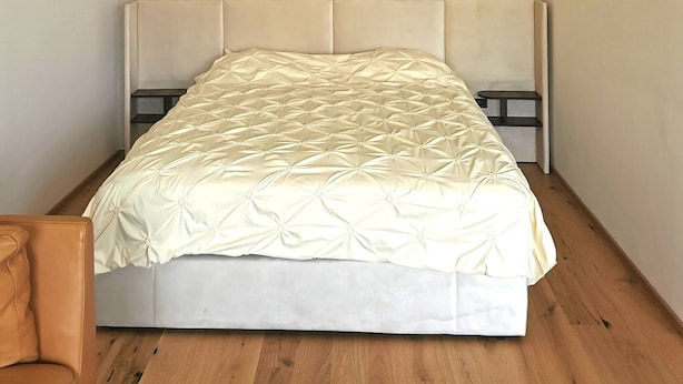 A bedroom with a bed, a wooden floor, a headboard, and a hanging light fixture. - Free Parking, Center Location, Nuslesky Pivovar Sunset Balcony Home (Prague)