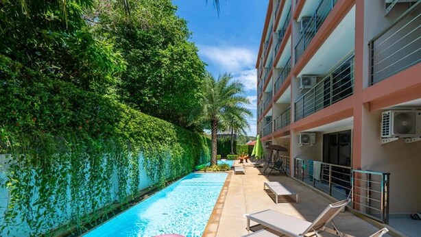A pool area with lounge chairs and a water slide. - Chill & Relax Stay at Rawai Condo 311 (Rawai)