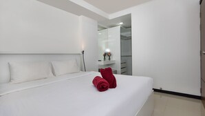 A modern hotel room with a large bed, white linens, and a red towel. - Chill & Relax Stay at Rawai Condo 311 (Rawai)