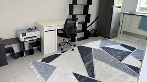 A modern office space with a desk, chair, and shelves. - Cozy and private one bedroom studio with double bed for couples or single (Busby)