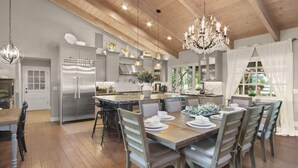 A spacious kitchen with a large island, stainless steel appliances, and hanging pendant lights. - @ Marbella Lane - Alpaca Farm House l Pool (Modesto)