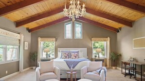 A bedroom with a large bed, two armchairs, a chandelier, and two windows with curtains. - @ Marbella Lane - Alpaca Farm House l Pool (Modesto)