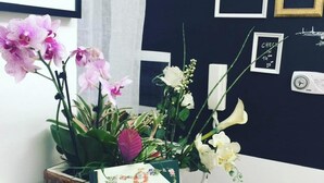 Ein Zimmer mit einer dunkelblauen Wand, einem gerahmten Zertifikat und einer Vase mit Blumen.