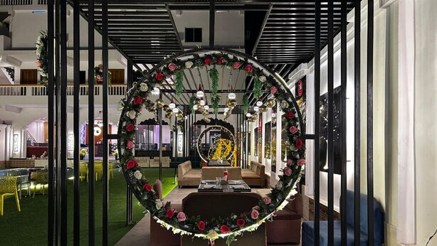 Een modern interieur met een ronde bloemstelling, een bank en een eethoek.