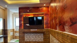 Een hotelkamer met een houten wand, een tv boven een open haard en een decoratief behang.