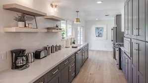 Una cucina moderna con elettrodomestici integrati, un piano di lavoro lungo e vista sull'area pranzo.