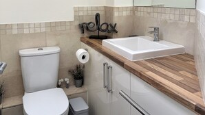Ein modernes Badezimmer mit Toilette, Waschbecken und Spiegel.