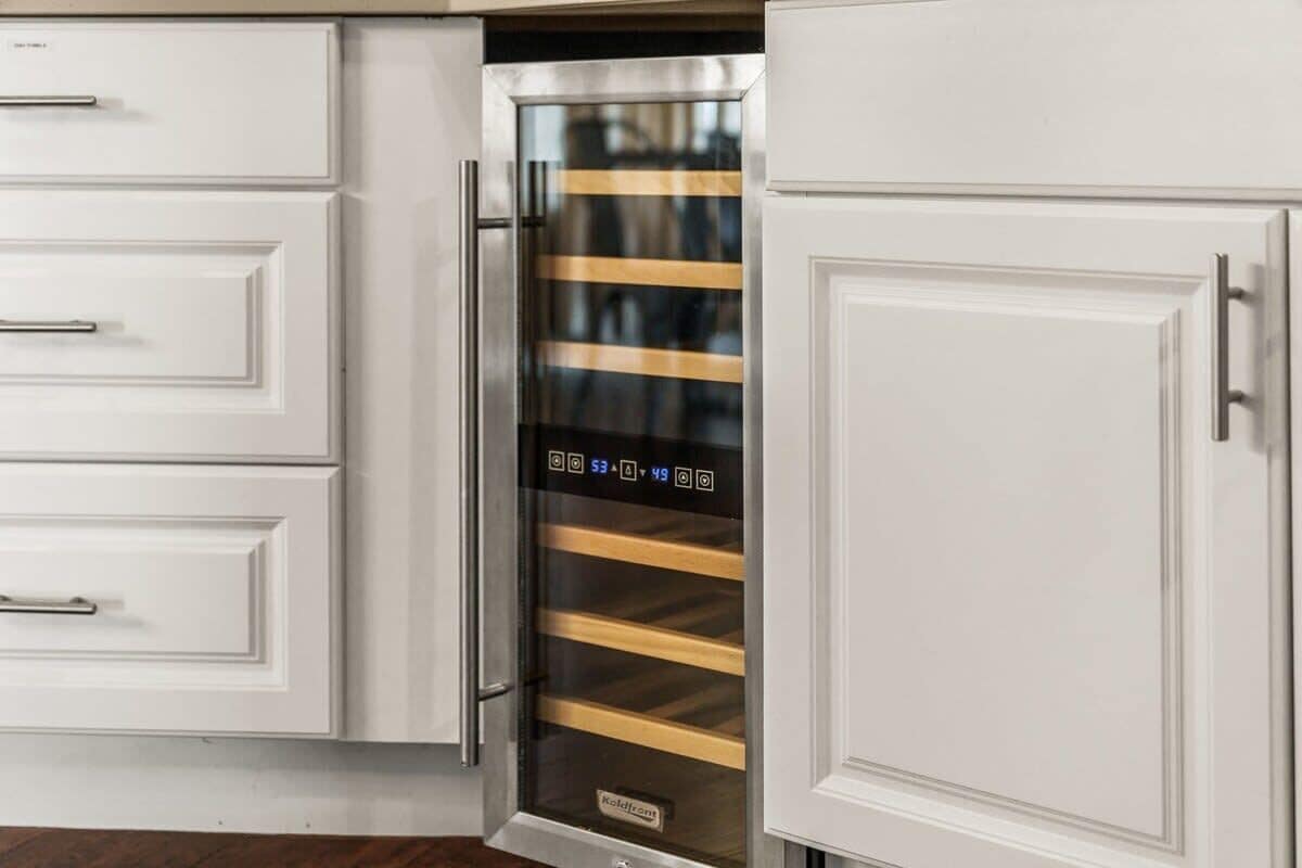 A kitchen with white cabinetry and a stainless steel appliance with a digital display.