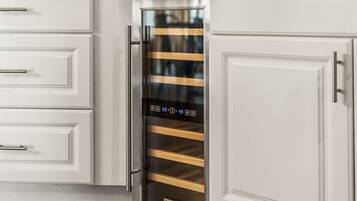 A kitchen with white cabinetry and a stainless steel appliance with a digital display.