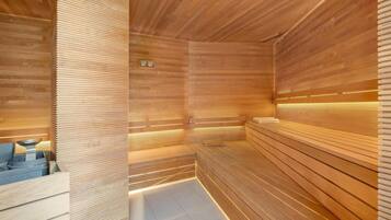A sauna with wooden slats and benches, a visible heater, and a tiled floor.