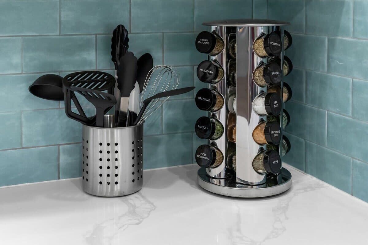 A kitchen with a spice rack and utensil holder.