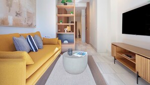 A modern living room with a mustard sofa, a round coffee table, and a TV on a wooden stand. - Genteel Home San Vicente III (Seville)