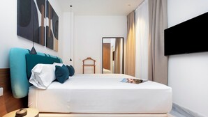 A modern hotel room with a large bed, a flat-screen TV mounted on the wall, and abstract art on the wall. - Genteel Home San Vicente III (Seville)