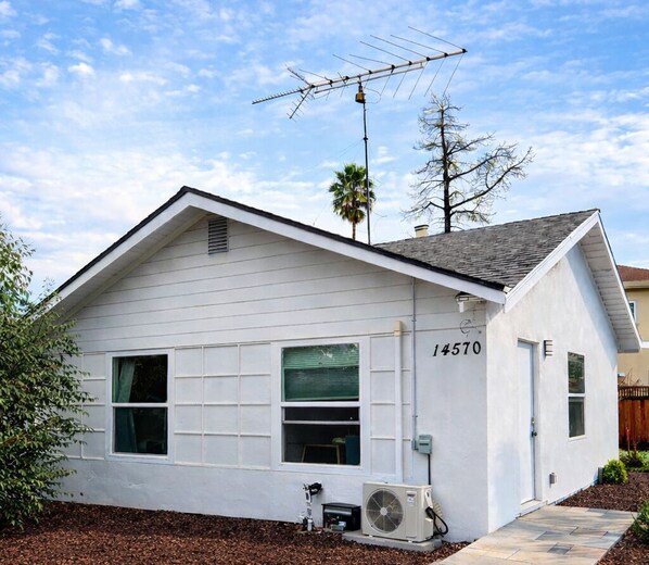 A single-story white building with a number 14570 on the side, an air conditioning unit, and a satellite dish. - @ Marbella Lane - Spacious 2BR Home Near Westgate  (San Jose)