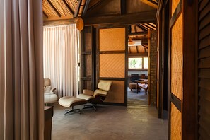A modern interior with a wooden ceiling, a large window, and a seating area with two chairs and a small table. - Ypê Greenhouse (Niteroi)