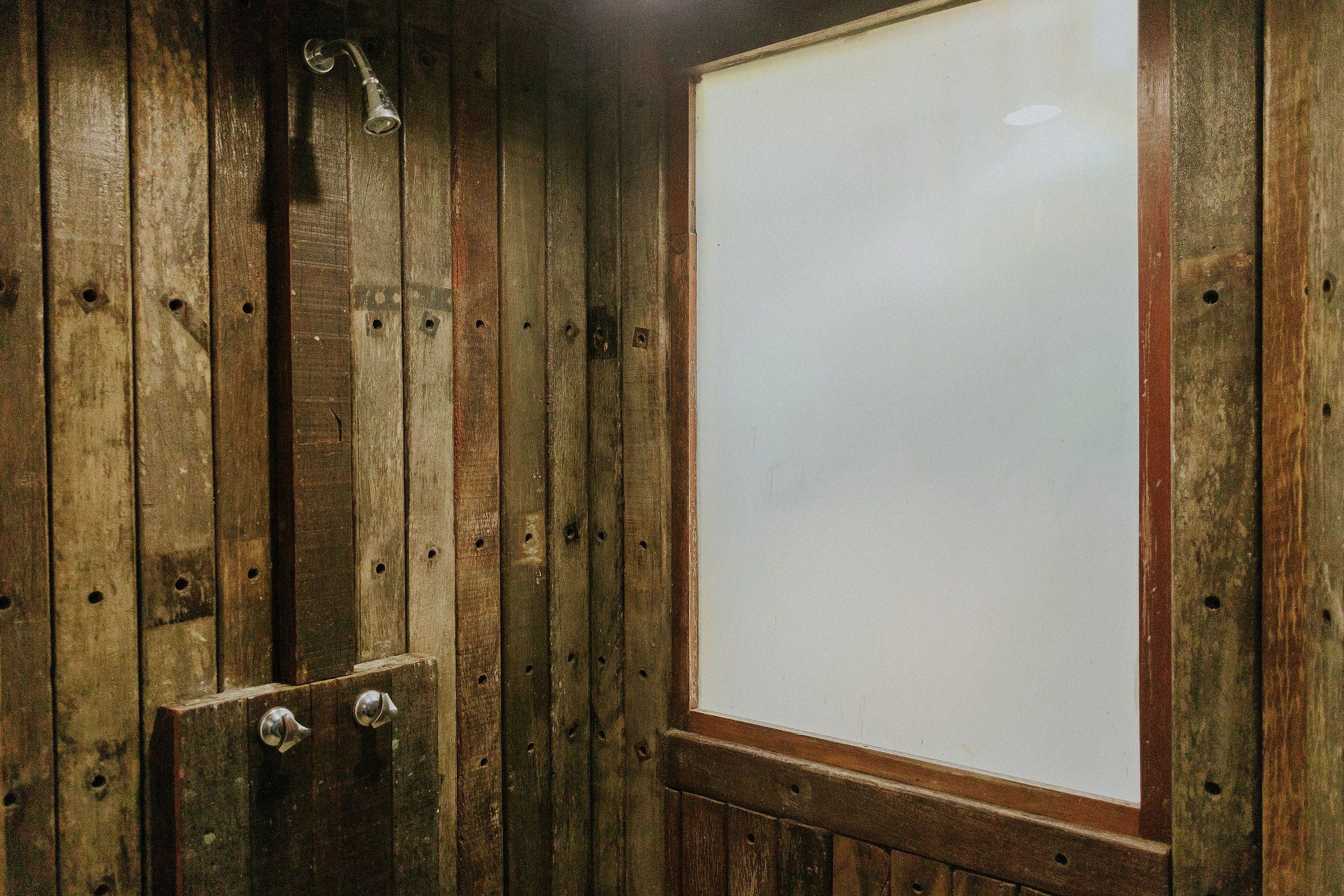 A wooden interior with a large white window and a door with two metal handles.