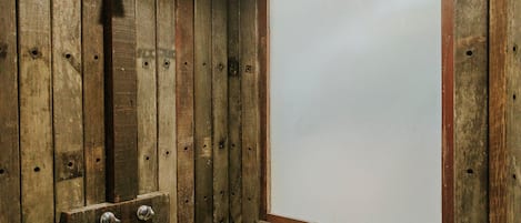 A wooden interior with a large white window and a door with two metal handles.