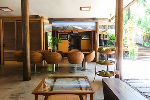 A spacious interior with wooden furniture, a glass table, and a view of a snowy landscape through large windows. - Ypê Greenhouse (Niteroi)