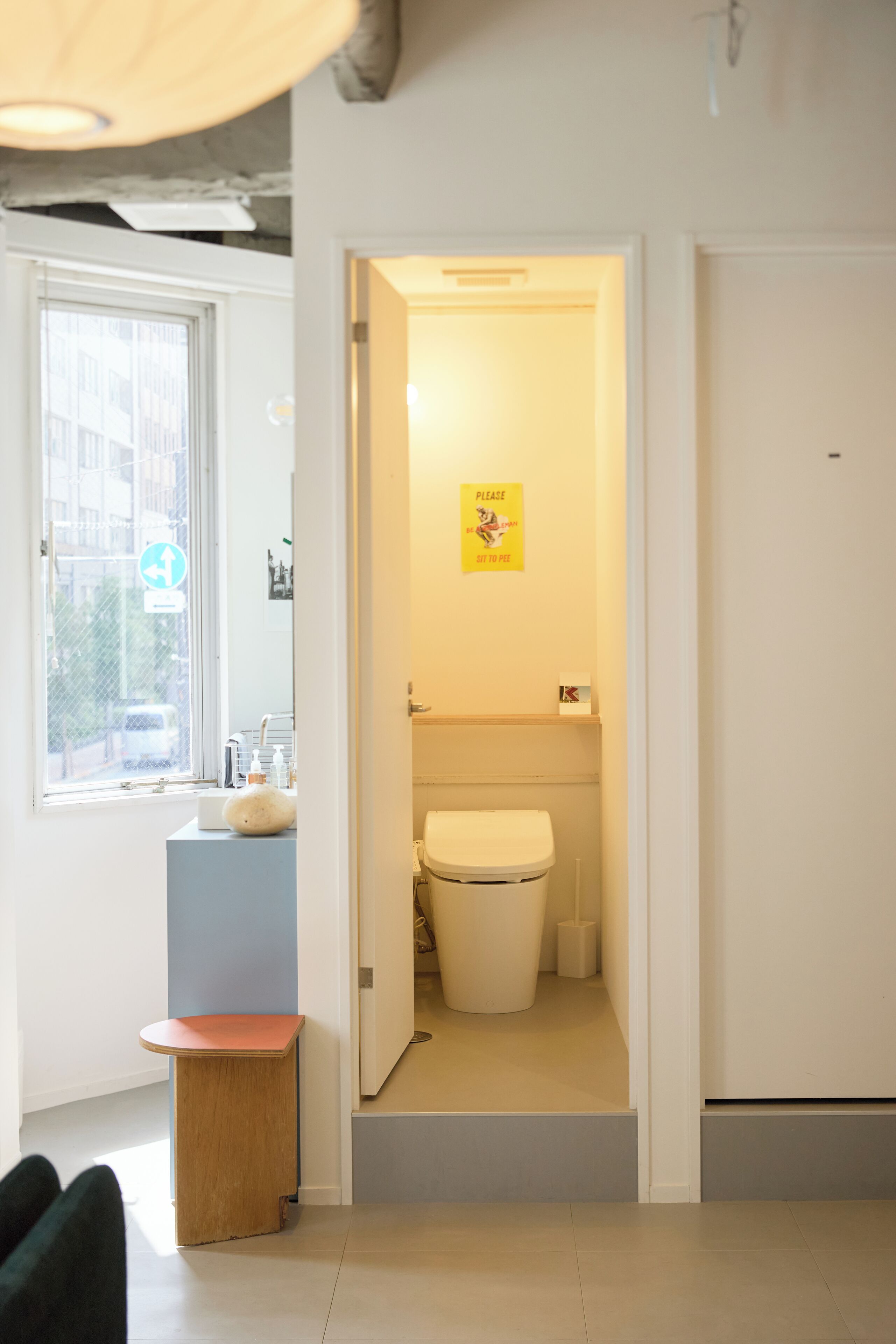 A bathroom with a toilet, sink, and a small table.