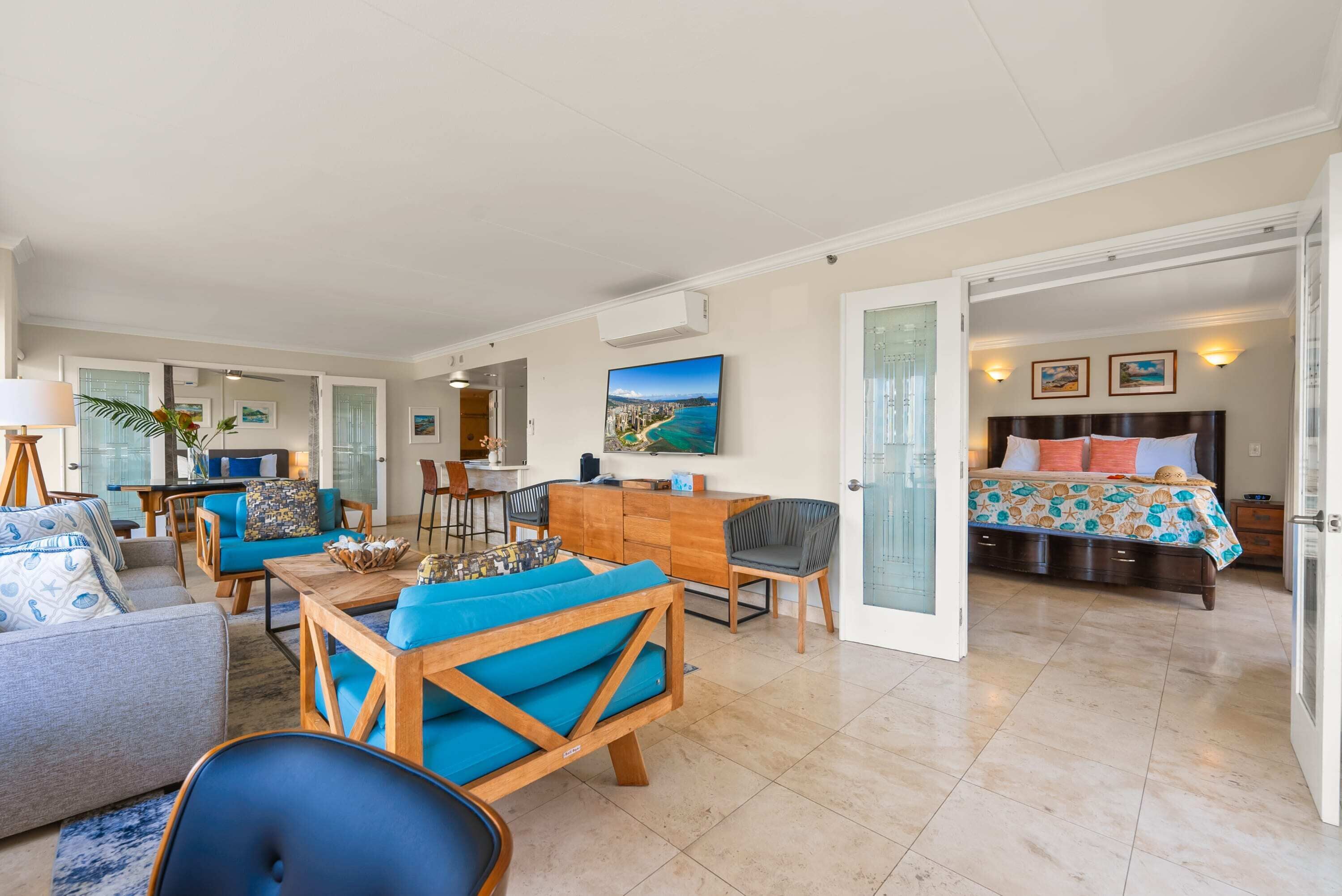 A spacious living area with a sofa, chairs, a wooden coffee table, and a dining area.