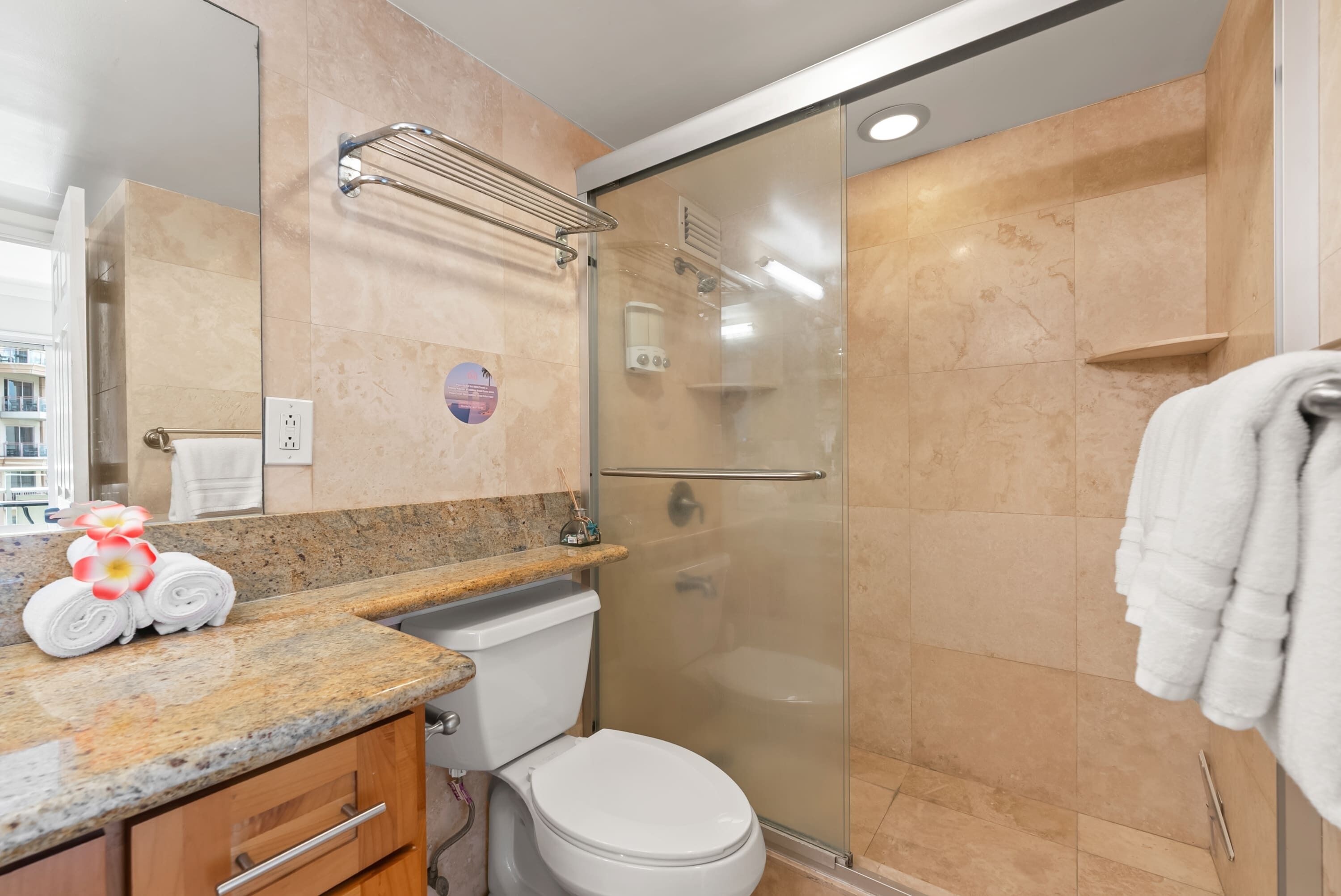 Une salle de bain moderne avec une douche à parois de verre, un comptoir en marbre et des toilettes.