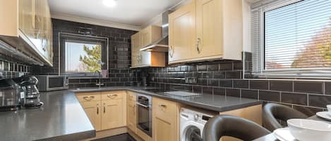 Enjoy cooking and dining in this well-lit kitchen with a coffee maker, microwave, oven, and dishwasher.