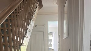 Eine Treppe mit Holzgeländer führt zu einer Tür.