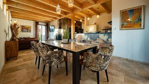 A spacious dining area with a large marble table and patterned chairs, wooden ceiling beams, and a painting on the wall. - Gorgeous home in Ehrenhausen (Ehrenhausen)