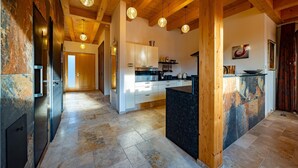 A modern kitchen with wooden beams, a central island, and pendant lighting. - Gorgeous home in Ehrenhausen (Ehrenhausen)