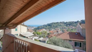 A balcony with a view of a hillside town and the sea. - Lovely home in Imperia with WiFi (Imperia)