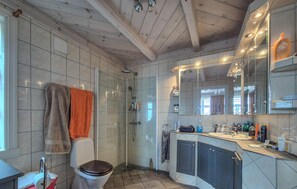 Une salle de bain moderne avec une douche à parois de verre, des toilettes, un lavabo avec un miroir et une fenêtre.