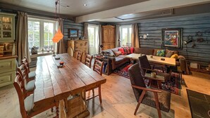 A cozy, rustic interior with a wooden dining table, chairs, a sofa, and a TV. - Nice home in Sjusjøen with WiFi (Sjusjøen)