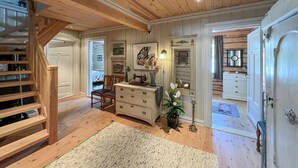 A spacious room with wooden floors, a staircase, a dresser, a chair, and a bed in the background. - Nice home in Sjusjøen with WiFi (Sjusjøen)