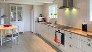 A modern kitchen with white cabinets, a wooden countertop, and a built-in oven. - 1 bedroom lovely home in Kättilstorp (Kättilstorp)