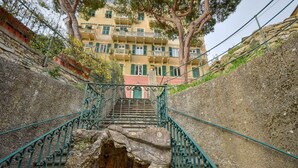 Eine Steintreppe mit aufwendigen Metallgeländern führt zu einem mehrstöckigen Gebäude mit Balkonen.