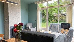 Ein modernes Wohnzimmer mit einer Couch, einem Esstisch und einem Fernseher.