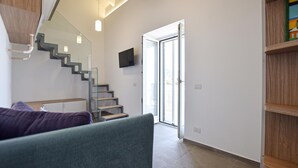 A modern interior with a staircase, a flat-screen TV, and a sliding glass door leading outside. - 2 bedroom beautiful home in Castellabate (Castellabate)