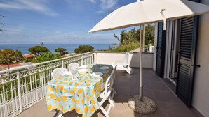 A balcony with a table set for two, overlooking a coastal view. - 2 bedroom beautiful home in Castellabate (Castellabate)