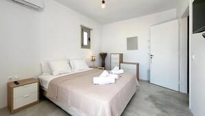 A bedroom with a bed, bedside tables, a dresser, a mirror, and a door. - Amazing home in Xylokastro with house a mountain view (Xylokastro)