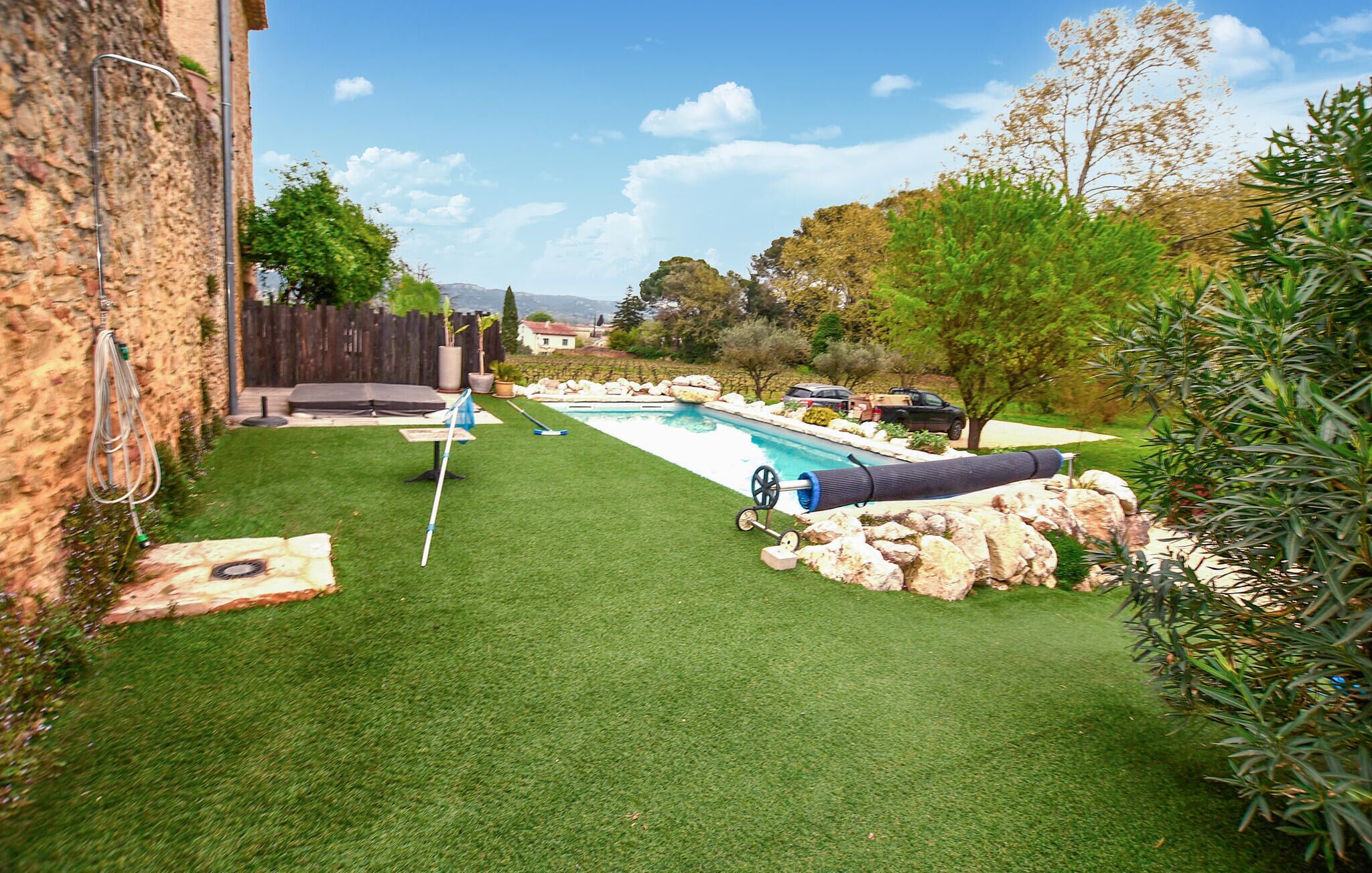 Un pati amb piscina, un trampolí i un jardí de pedres.