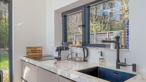 A modern kitchen with a built-in stove, a coffee maker, and a sink.